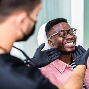 Dentist looking at patient's smile in treatment room