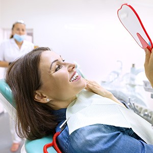 Patient showing confident smile after receiving dental implant restoration