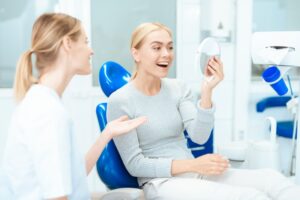 Woman looking at her teeth after a smile makeover